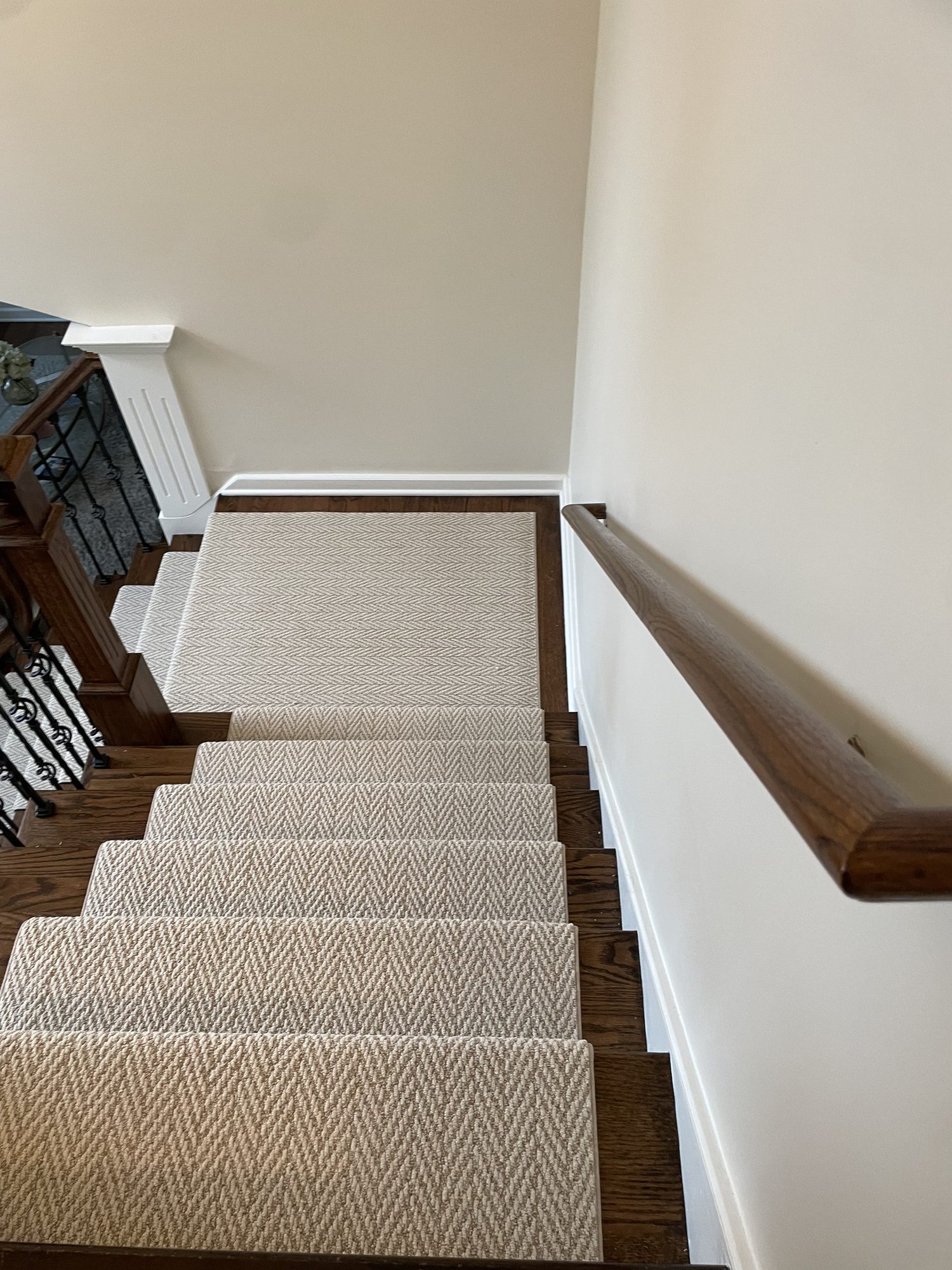 Herringbone runner from the top of the stairs View down the stairs from the top showing the herringbone runner on oak treads with a wall handrail on the right