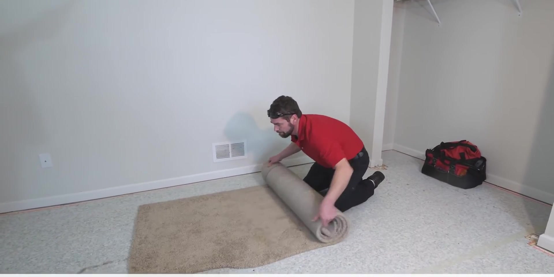 At Home Flooring installer rolling out carpet for an install